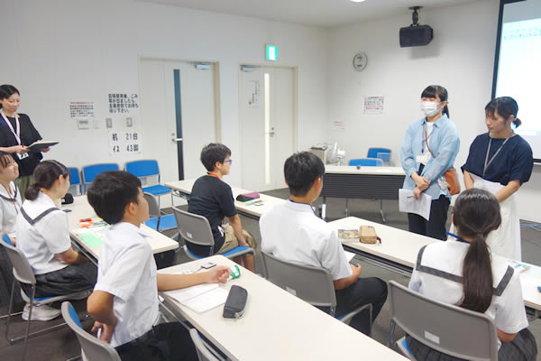 長崎純心大学の学生が、ビブリオバトルについて中学生に説明している。